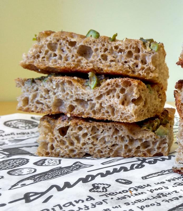 A stack of three slices of green olive focaccia