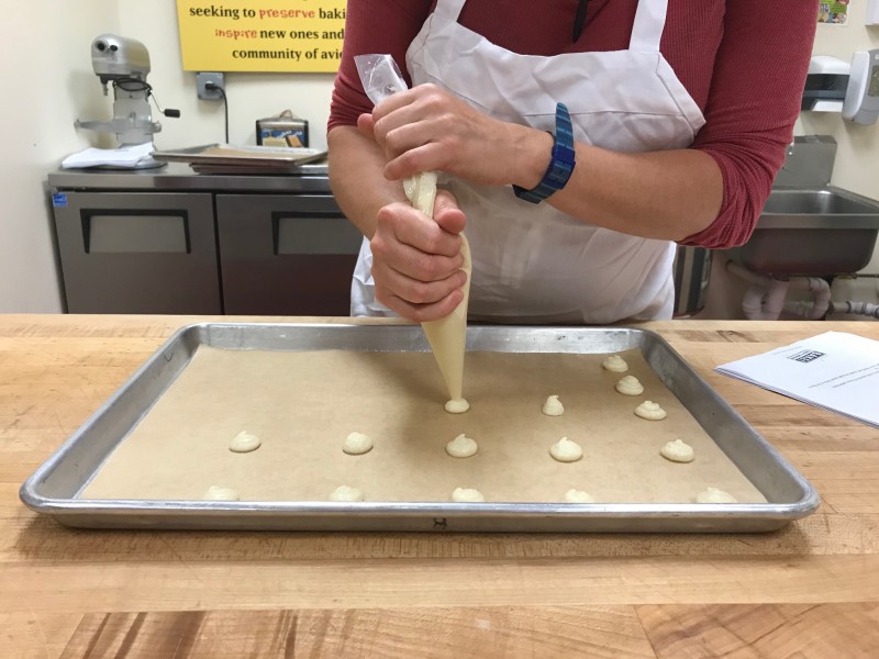 hands holding a piping bag, piping cookies